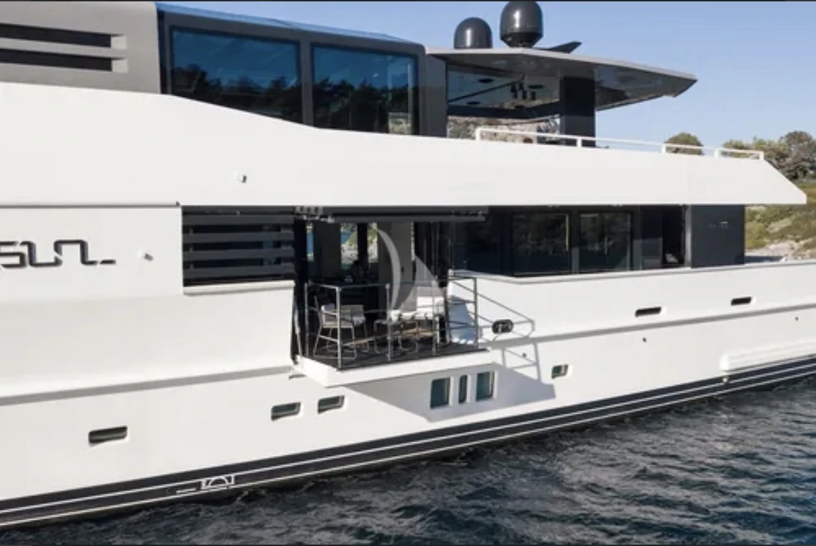Yacht salon opening towards a Mediterranean cruising landscape