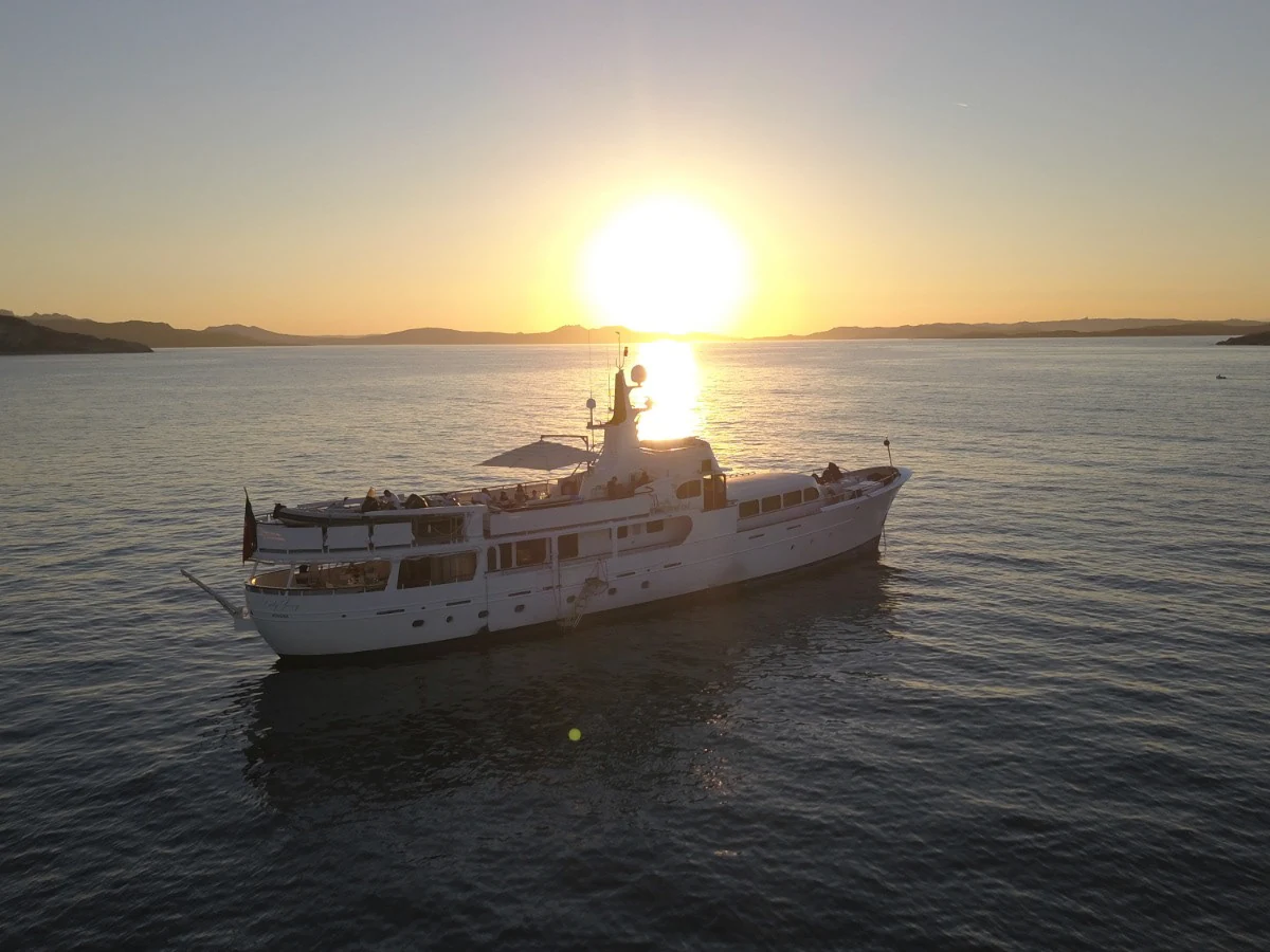 Classic-profile motor yacht at anchor in warm evening light