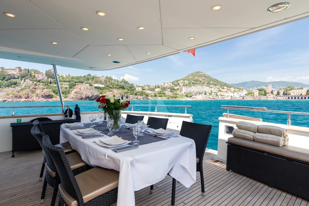 Exterior yacht dining table prepared beside a coastal view