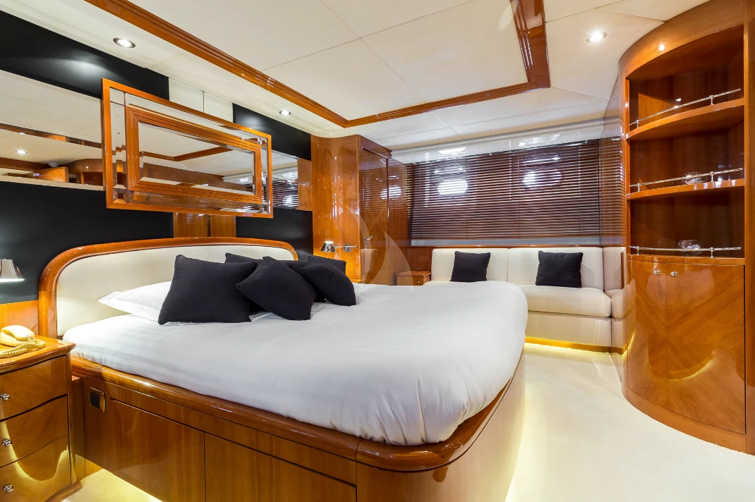 Espace de repos de yacht avec grand lit, rangements et fauteuil