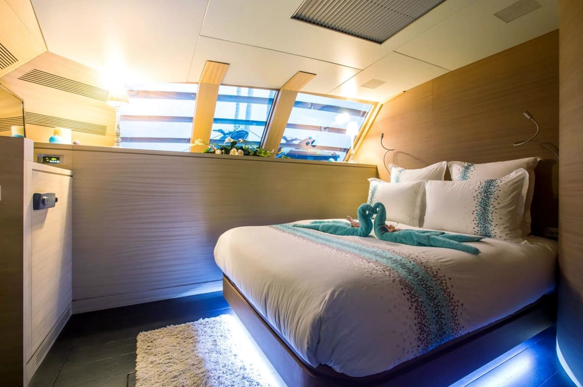 Yacht sleeping space with a double bed and light timber finishes